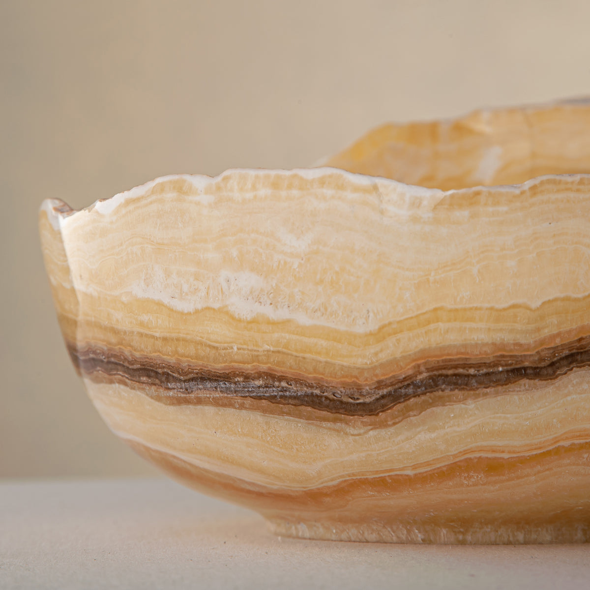 handcrafted onyx bowl with golden amber layers and organic asymmetrical rim for luxury decor

