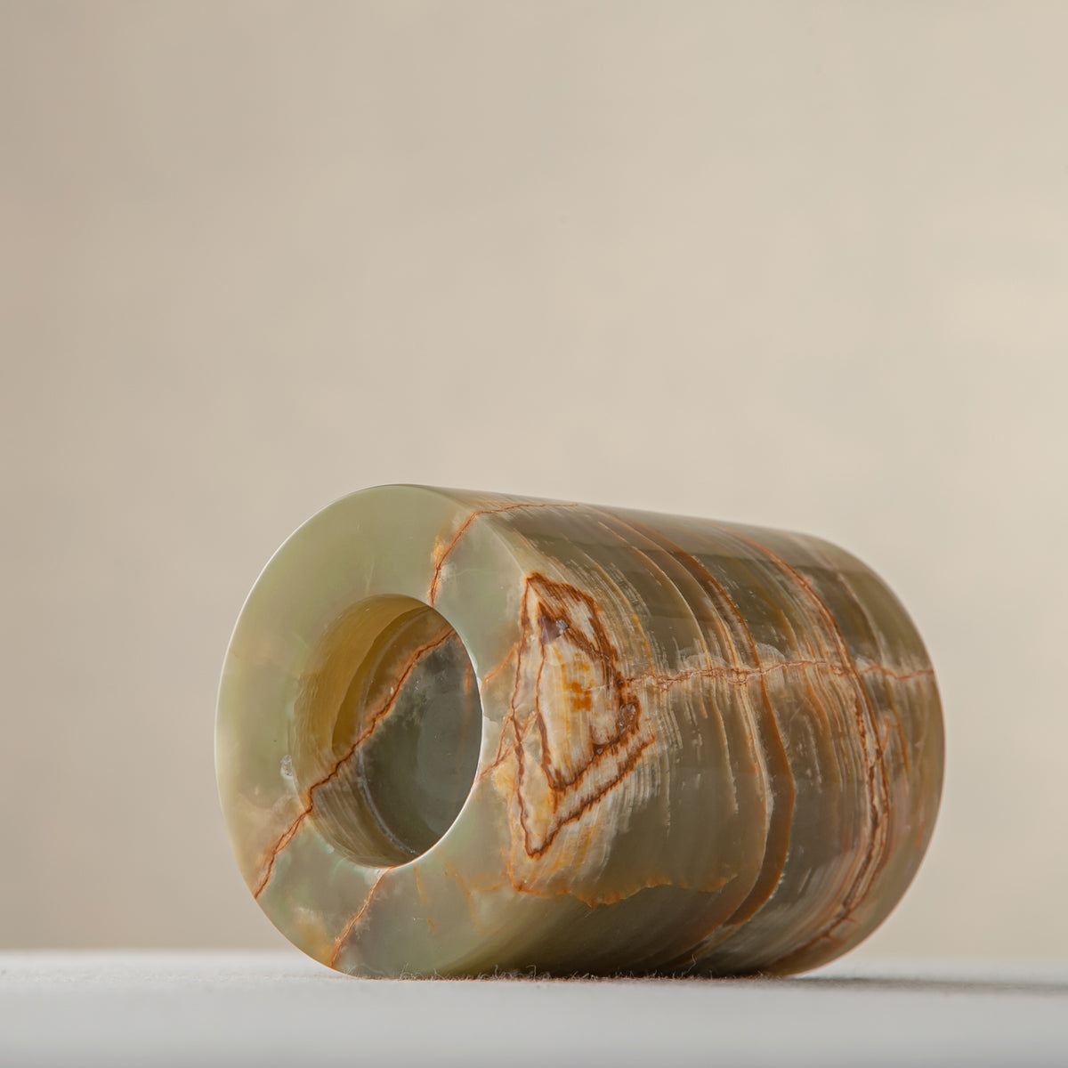 handcrafted onyx candle holder with translucent layered bands and warm amber veining for modern decor
