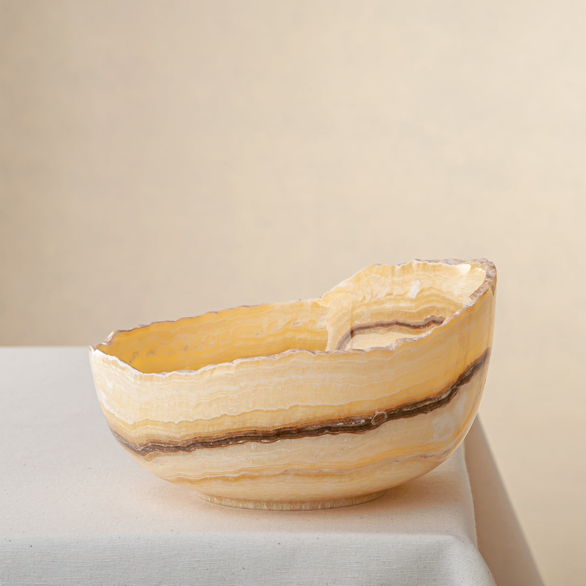 handcrafted onyx bowl with golden amber layers and organic asymmetrical rim for luxury decor
