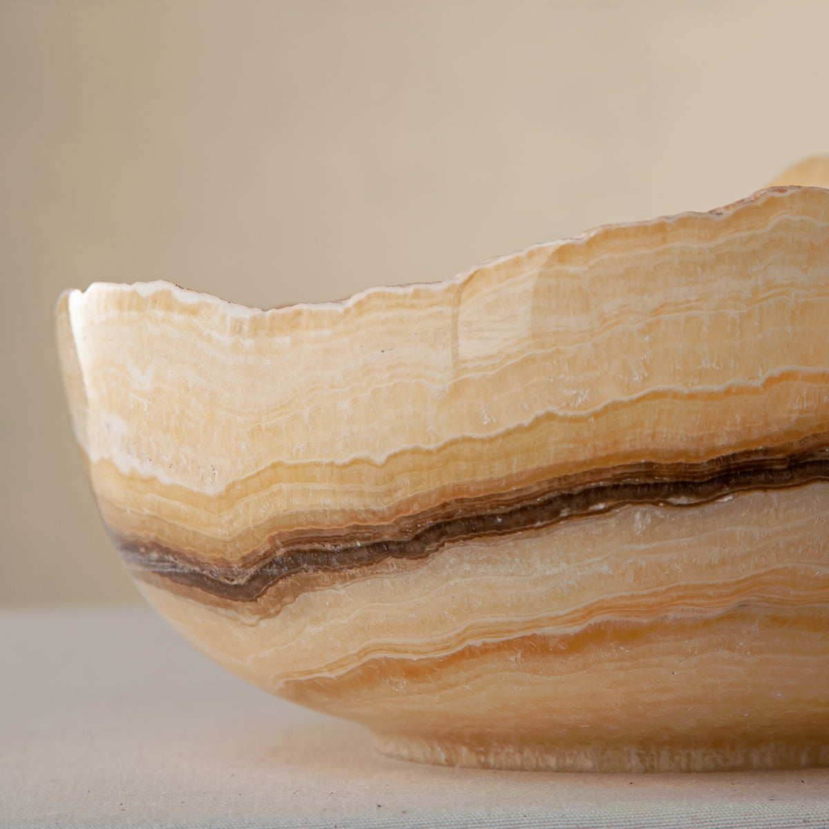 handcrafted onyx bowl with golden amber layers and organic asymmetrical rim for luxury decor
