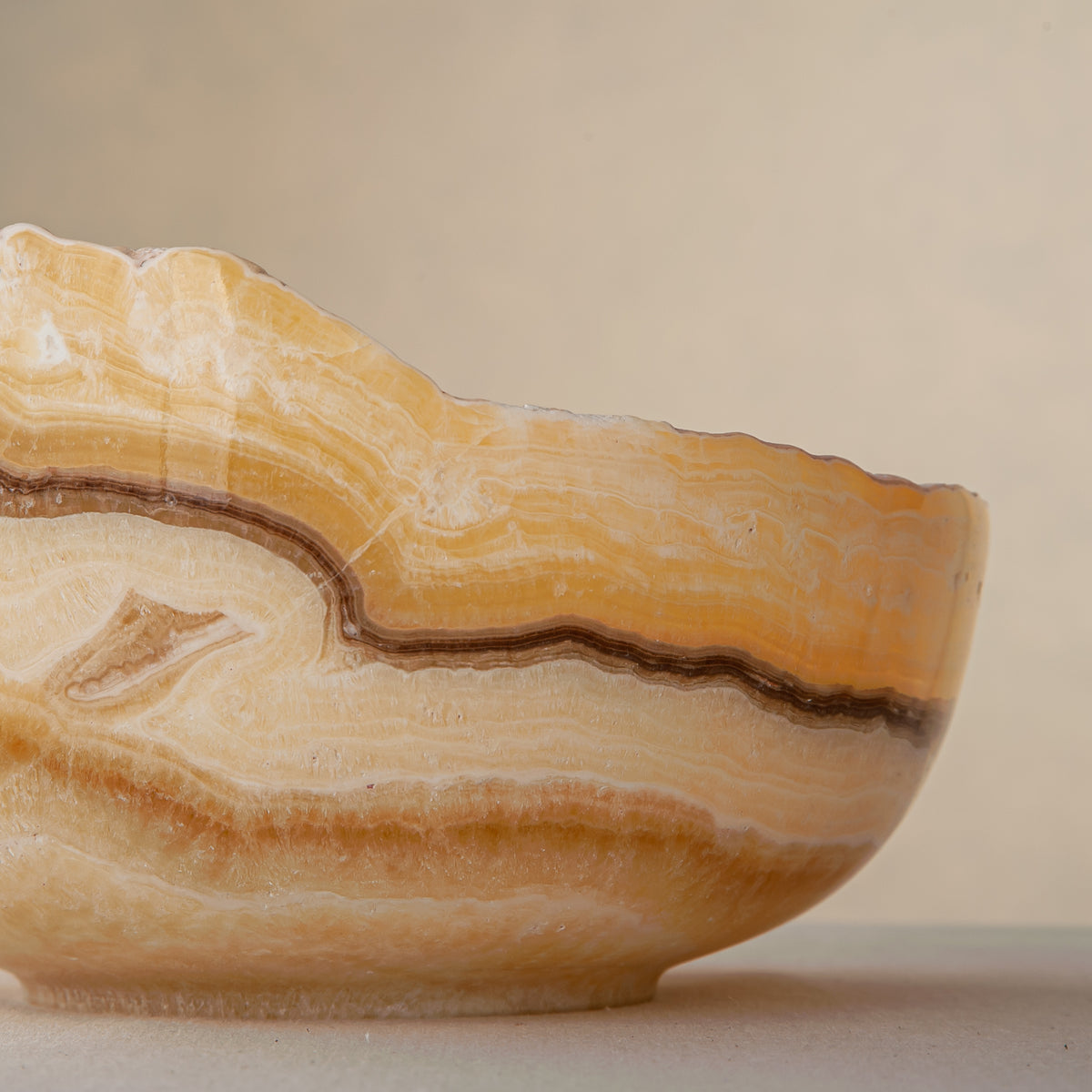 handcrafted onyx bowl with golden amber layers and organic asymmetrical rim for luxury decor
