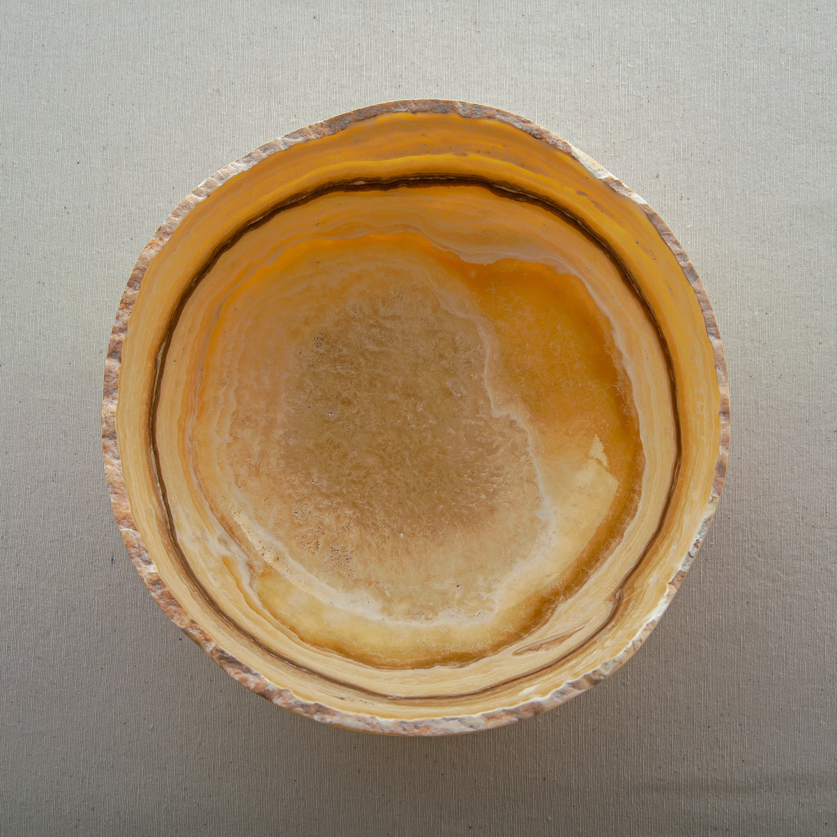 handcrafted onyx bowl with golden amber layers and organic asymmetrical rim for luxury decor
