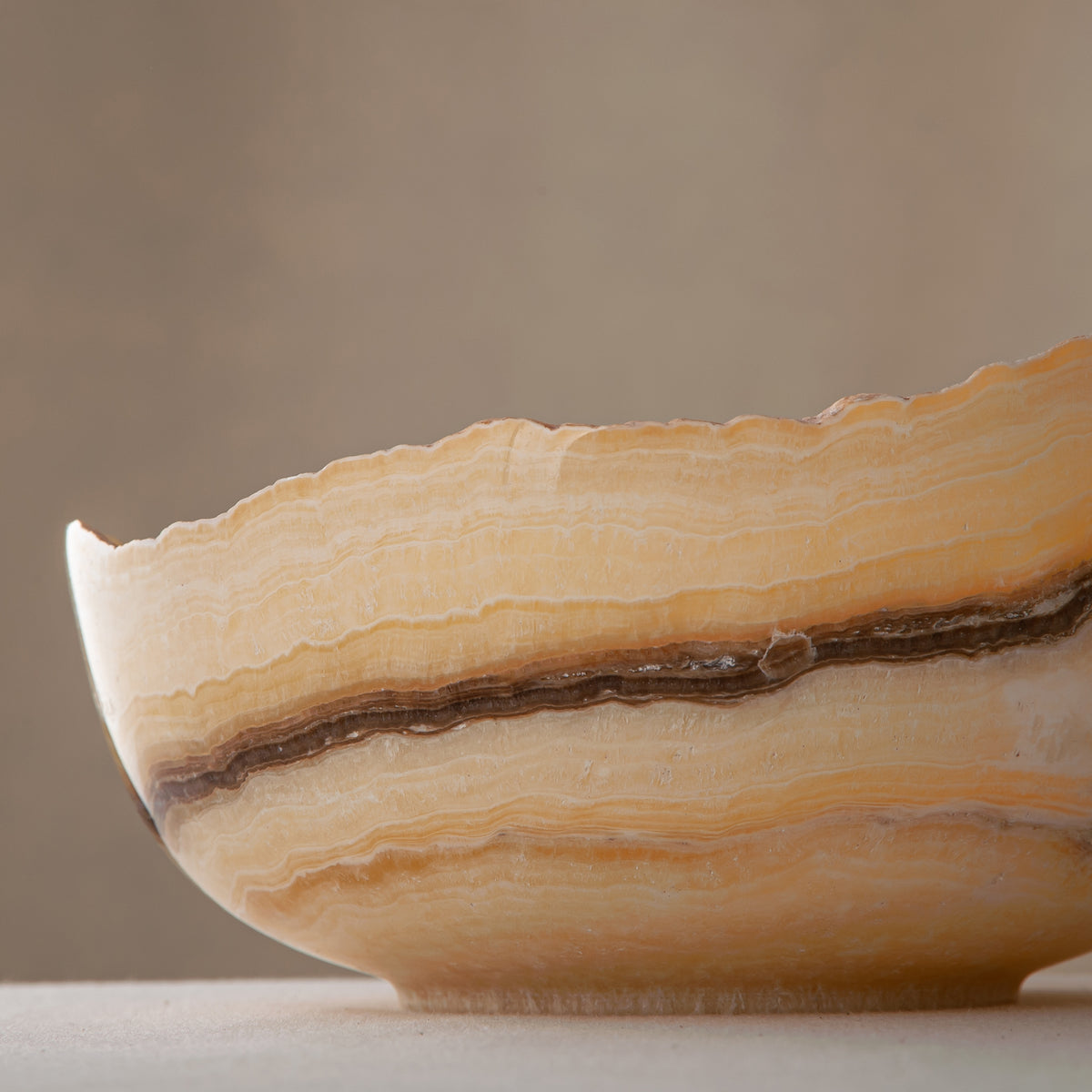 handcrafted onyx bowl with golden amber layers and organic asymmetrical rim for luxury decor
