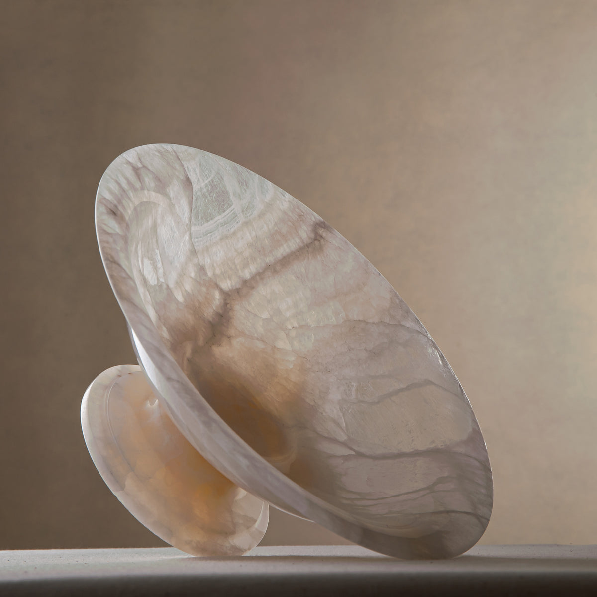 handcrafted onyx bowl with pedestal base translucent white stone and warm amber veining for centerpiece
