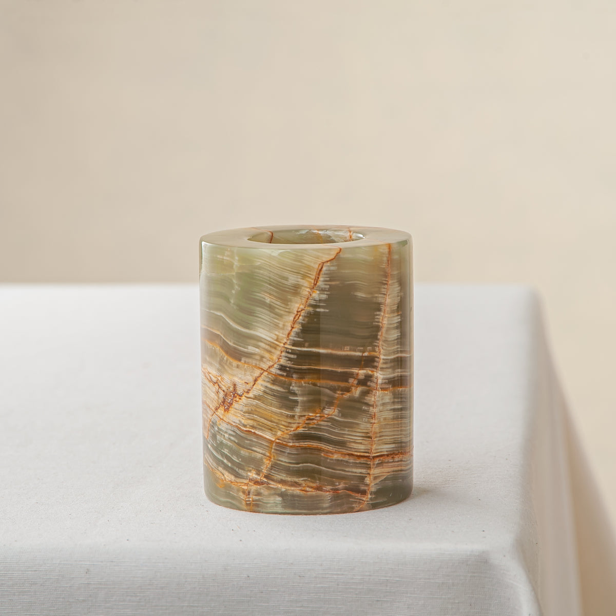 handcrafted onyx candle holder with translucent layered bands and warm amber veining for modern decor

